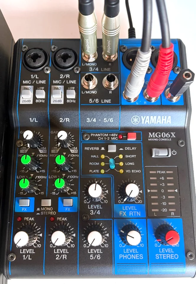 A Yamaha MG06X mixing console with audio cables connected